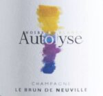 Flasche „Autolyse“ Champagner mit tiefgoldenem Schaumwein im Glas, feine Perlage sichtbar.